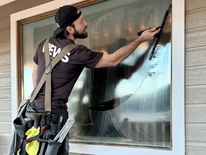 Views Window Cleaning technician squeegeeing a residential window